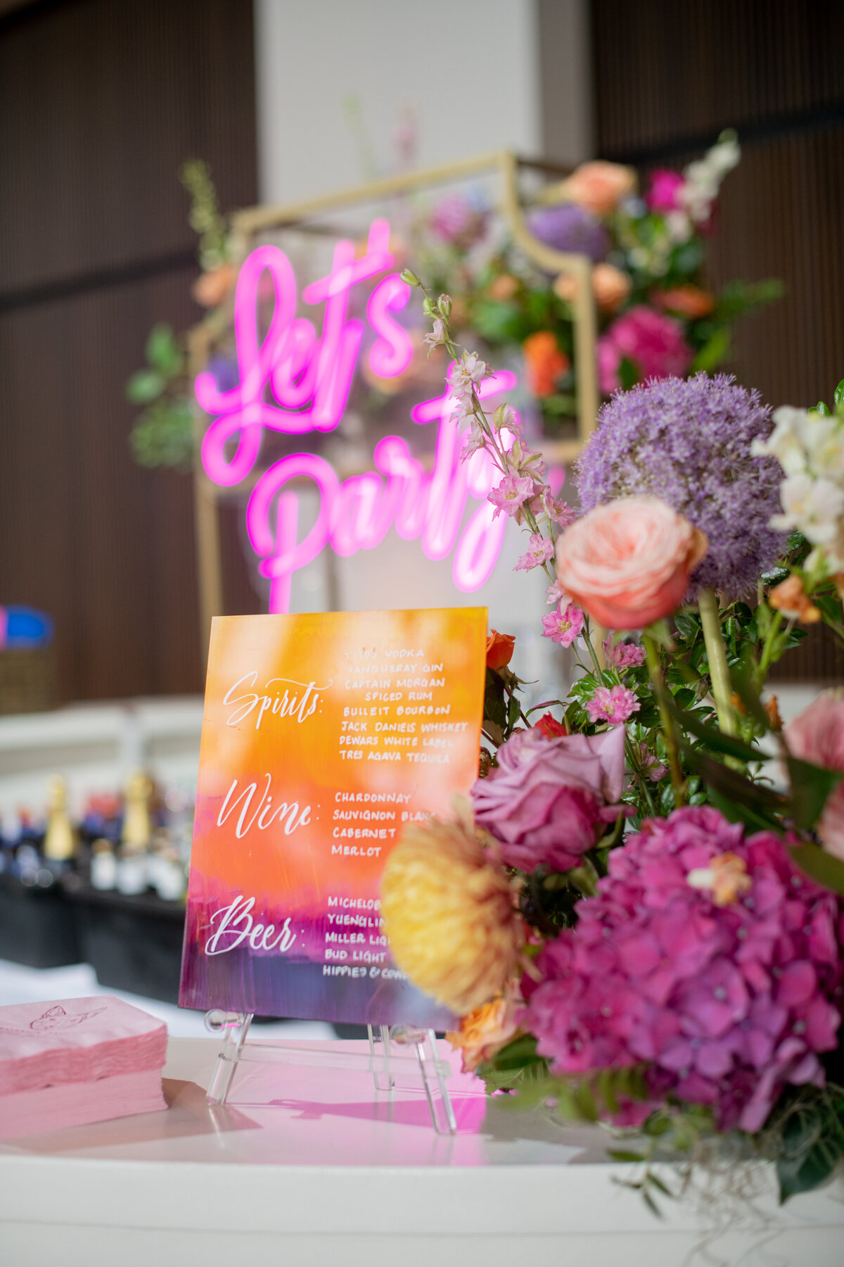 Cheerful sunset inspired summer wedding composed of petal heavy roses, garden roses, allium, orchids, ranunculus, eremurus, delphinium, and natural greenery creating hues of rosy pink, fuchsia, lavender, orange, and golden-yellow. Design by Rosemary and Finch in Nashville, TN.