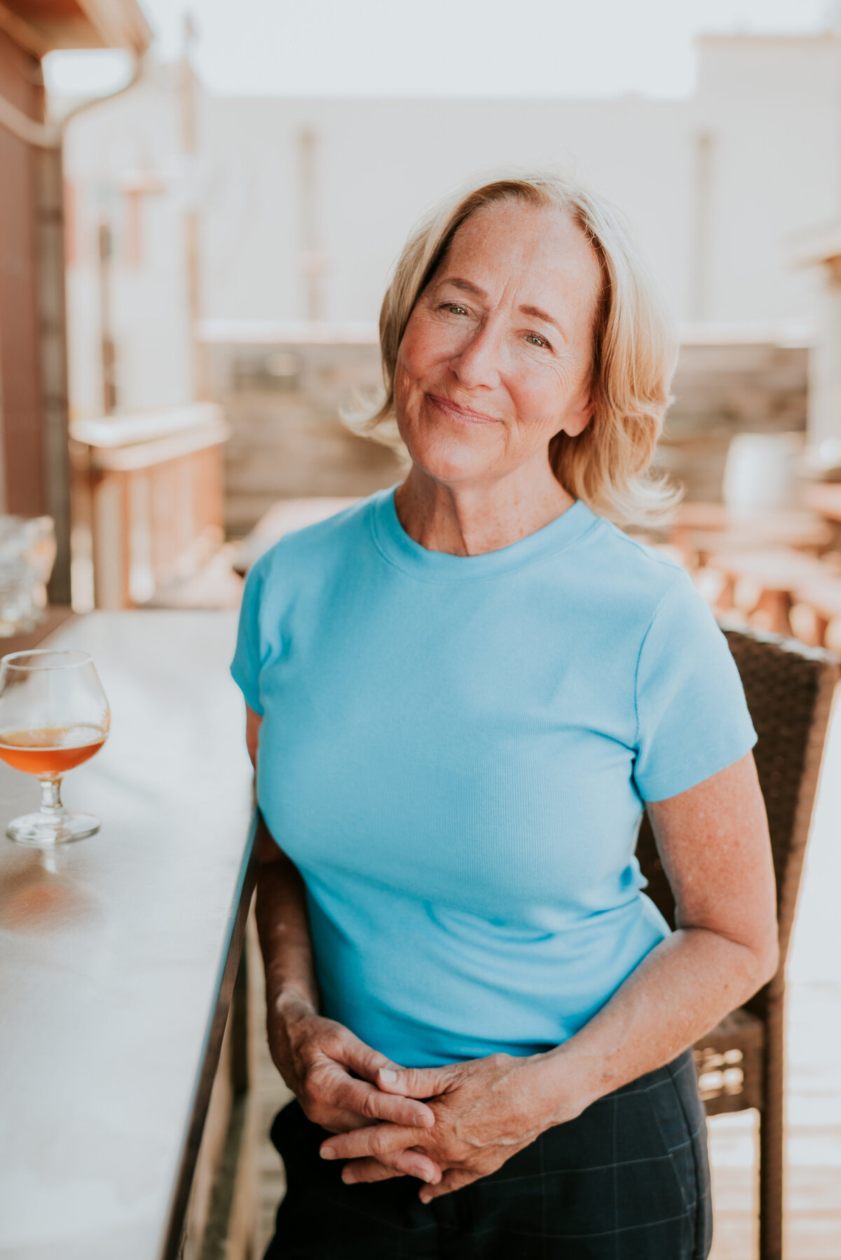 Lifestyle dating profile photo of Linda in a light blue top, sitting in a Minneapolis cafe with natural light.