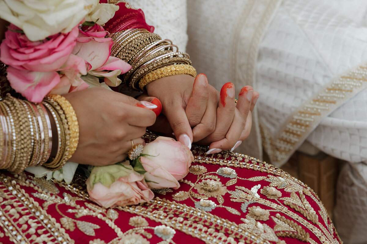 A couple holding hands during their Hindu Ceremony.