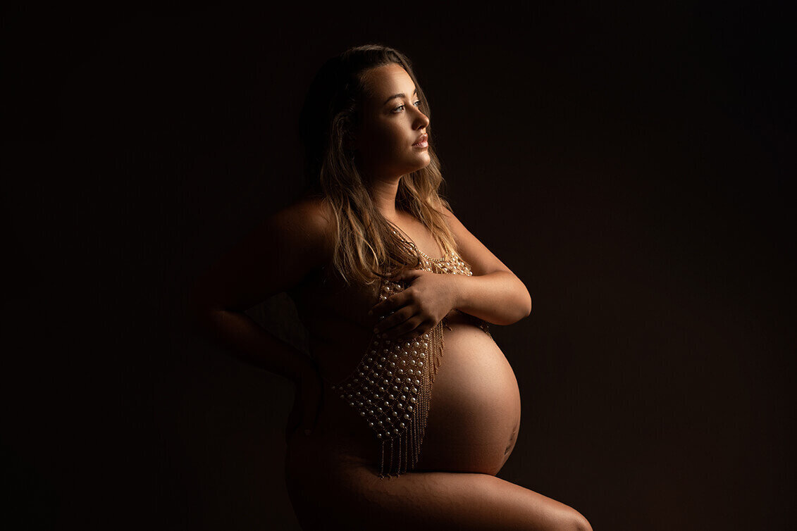 Pregnant woman backlight on dark backdrop