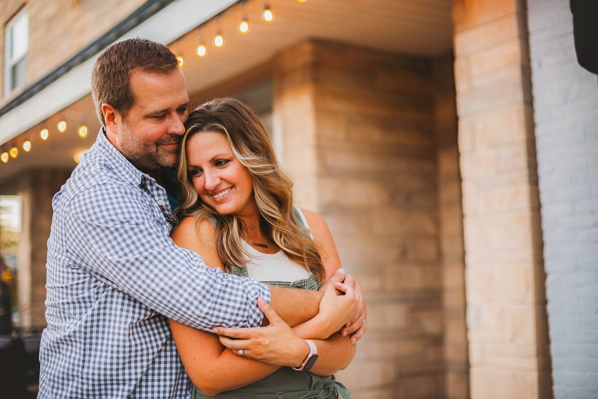oving-couple-embracing-under-warm-string-lights-in-downtown-fortville-indiana-during-an-evening-couples-photography-session