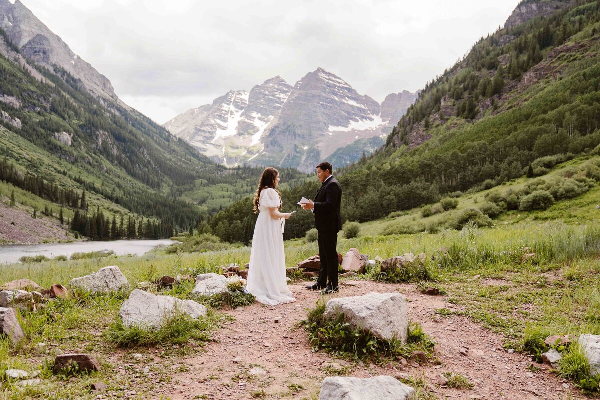Couple exchanges vows with the iconic Maroon Bells peaks in the background at Maroon Bells Amphitheater, Colorado.