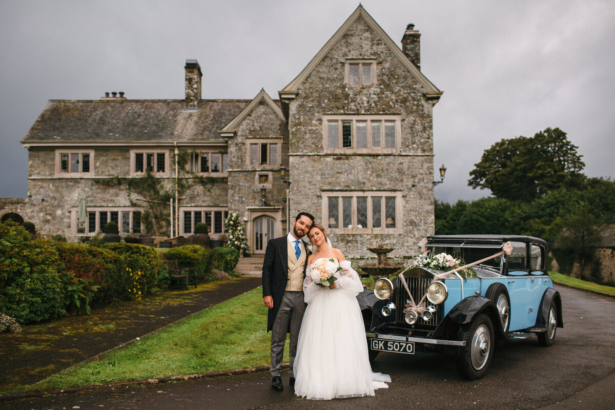 Couple pose outside Family Stately Home on their wedding day on Dartmoor 
