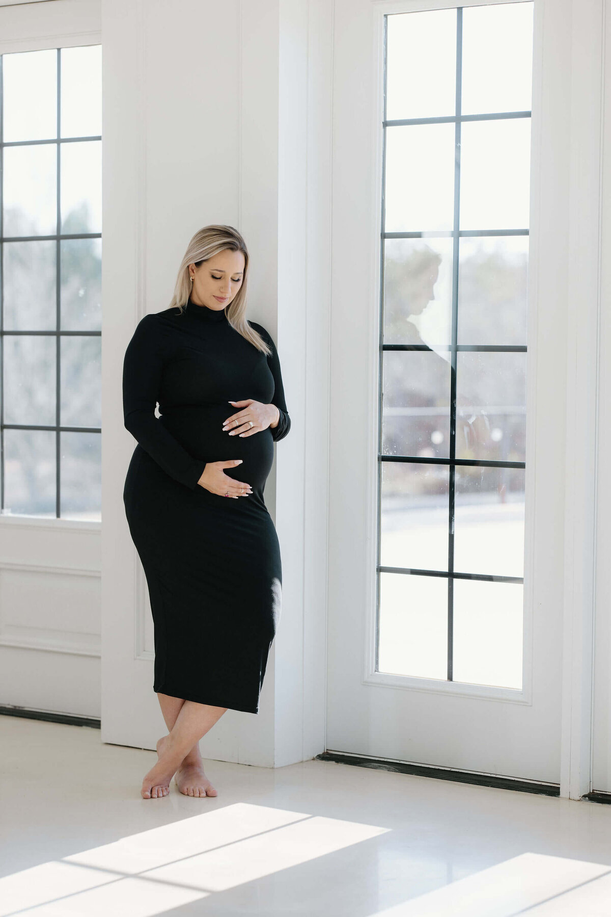 Fine art maternity photograph of expecting mom in elegant long black dress