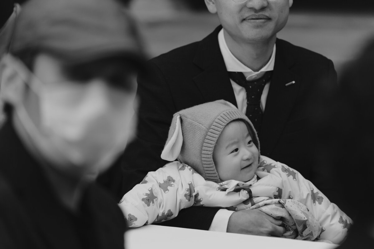 happy baby in his father's arms at a wedding in seoul