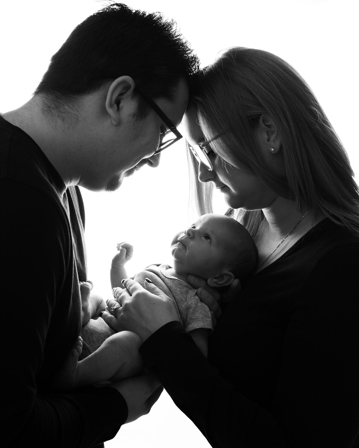 Black and white studio in Paris, Ontario newborn portrait with parents holding baby | Meraki Photographic Creations