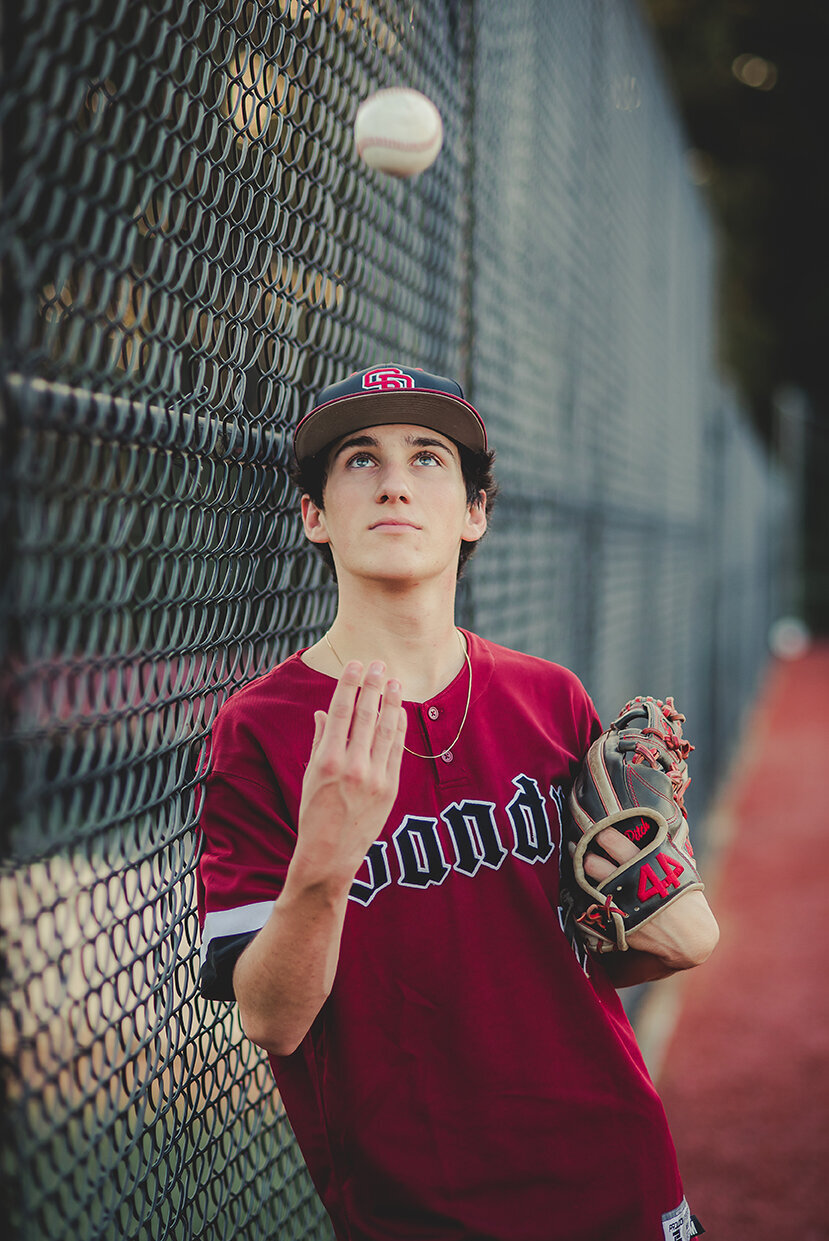 senior boy throwing baseball
