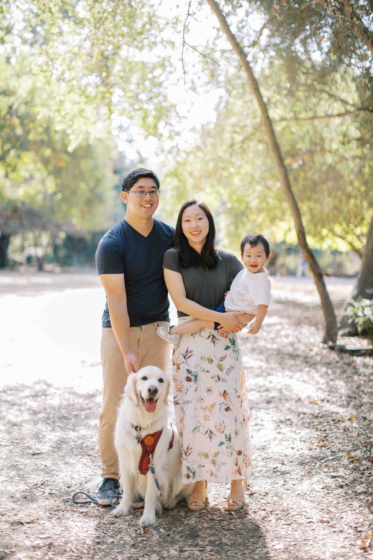 family of 3 with their white golden retriever