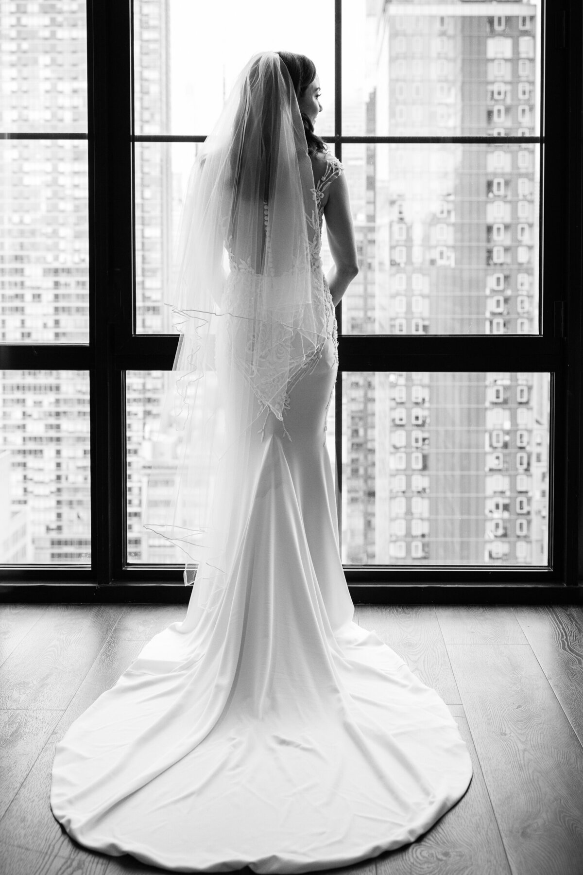 a shot framed in the window of the hotel showcases sarah's wedding dress and veil