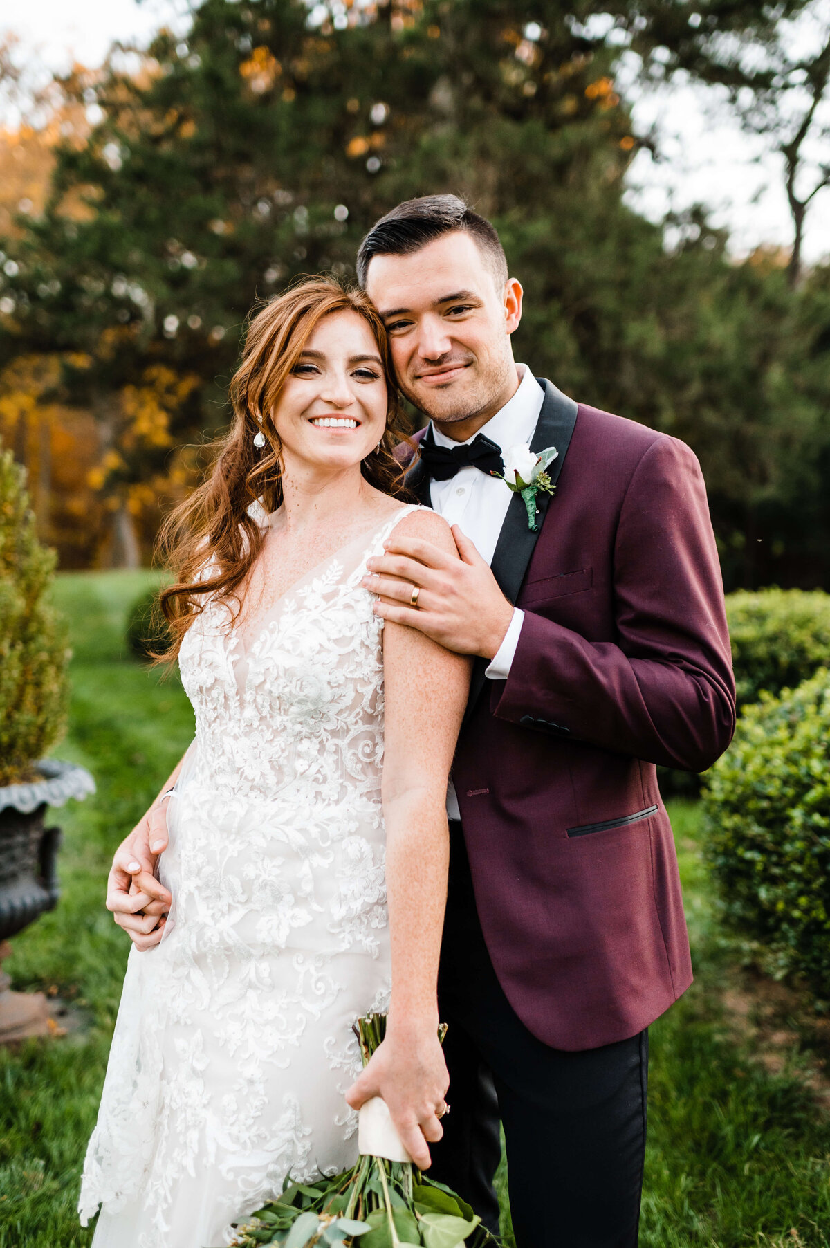 garden wedding with groom holding his bride by her shoulder and leaning his head to her and smiling whiel she smiles and holds her florals to her side captured by Virginia wedding photographer