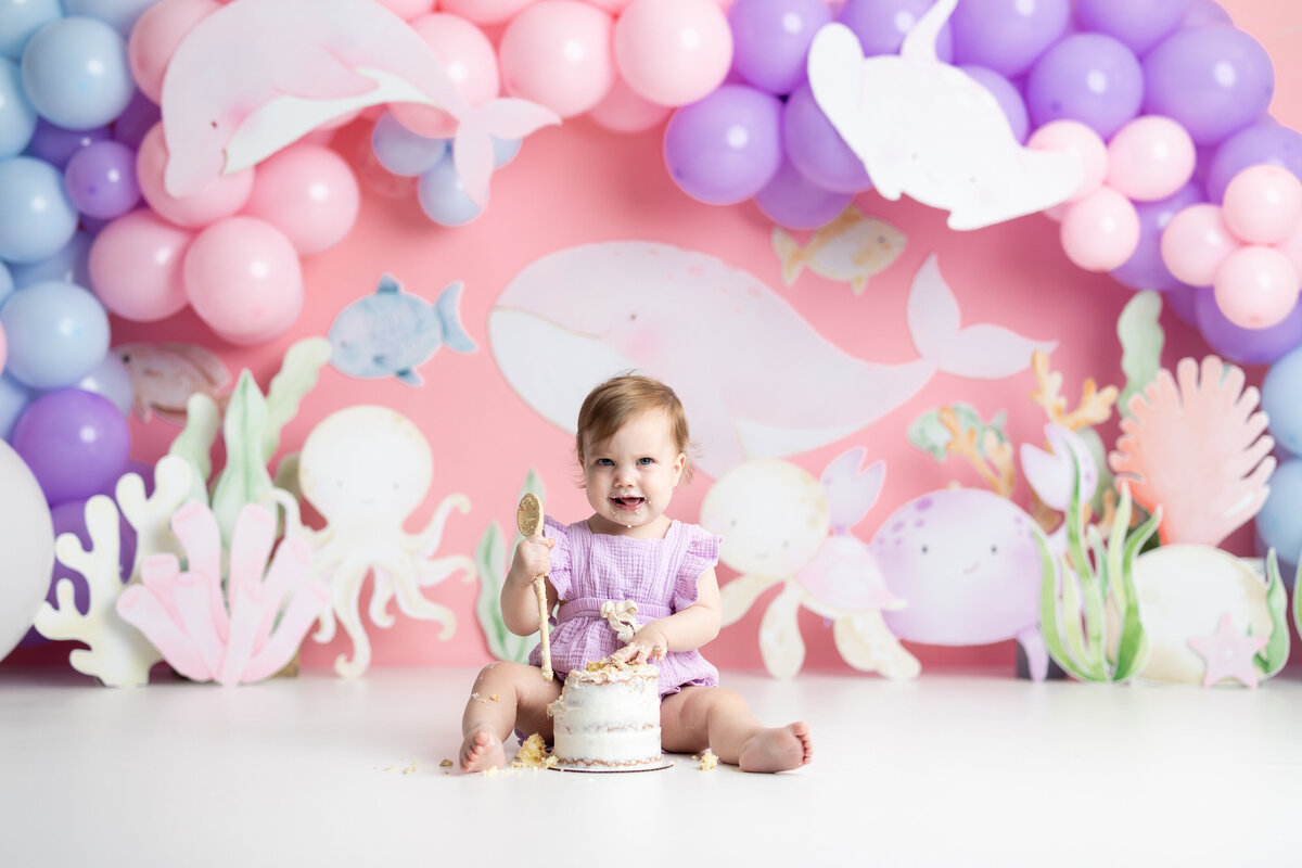 Baby girl with under the sea themed first birthday cake smash in Canton GA studio

