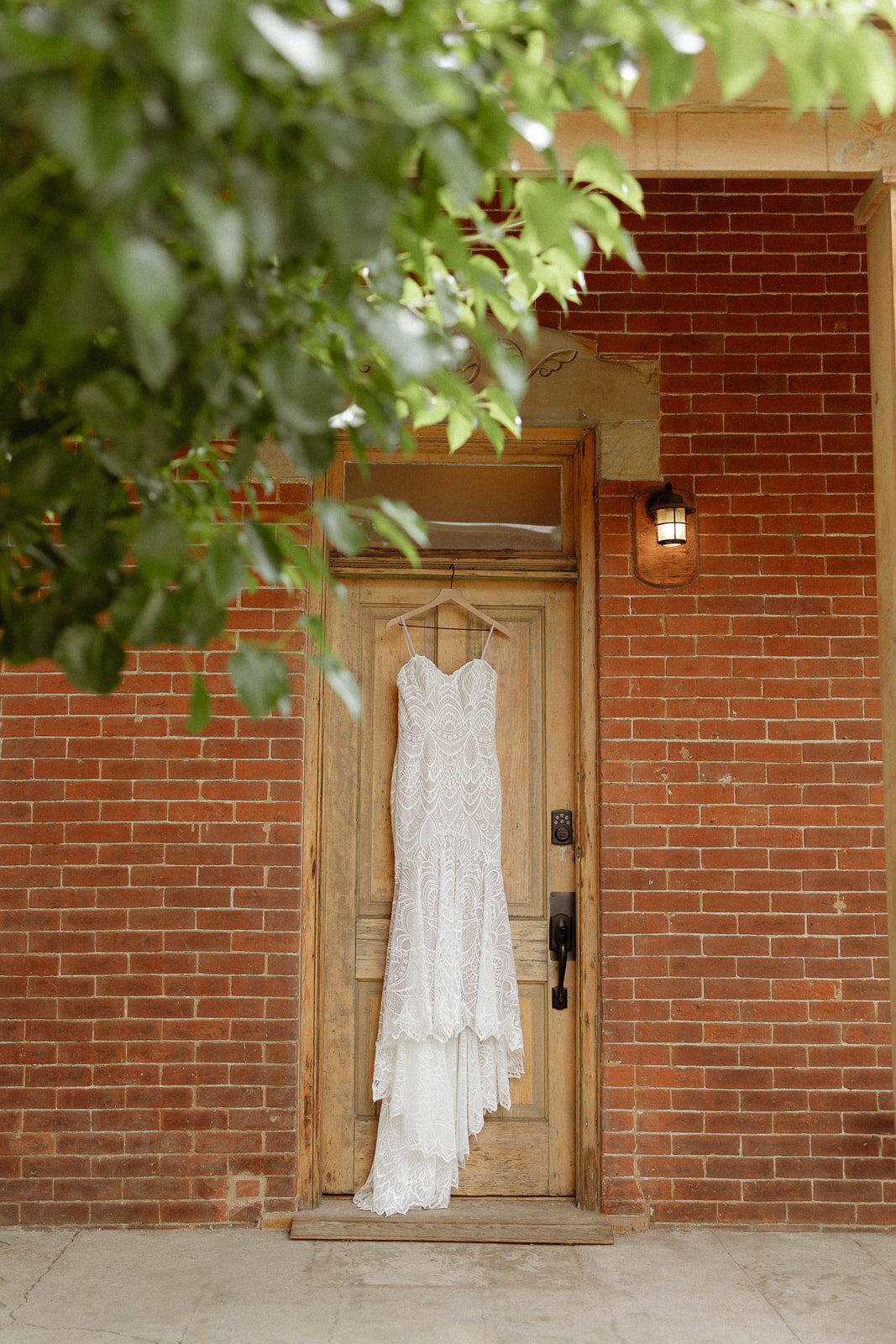 Bride's wedding dress hanging outside of the getting ready suite at Upper Larimer.