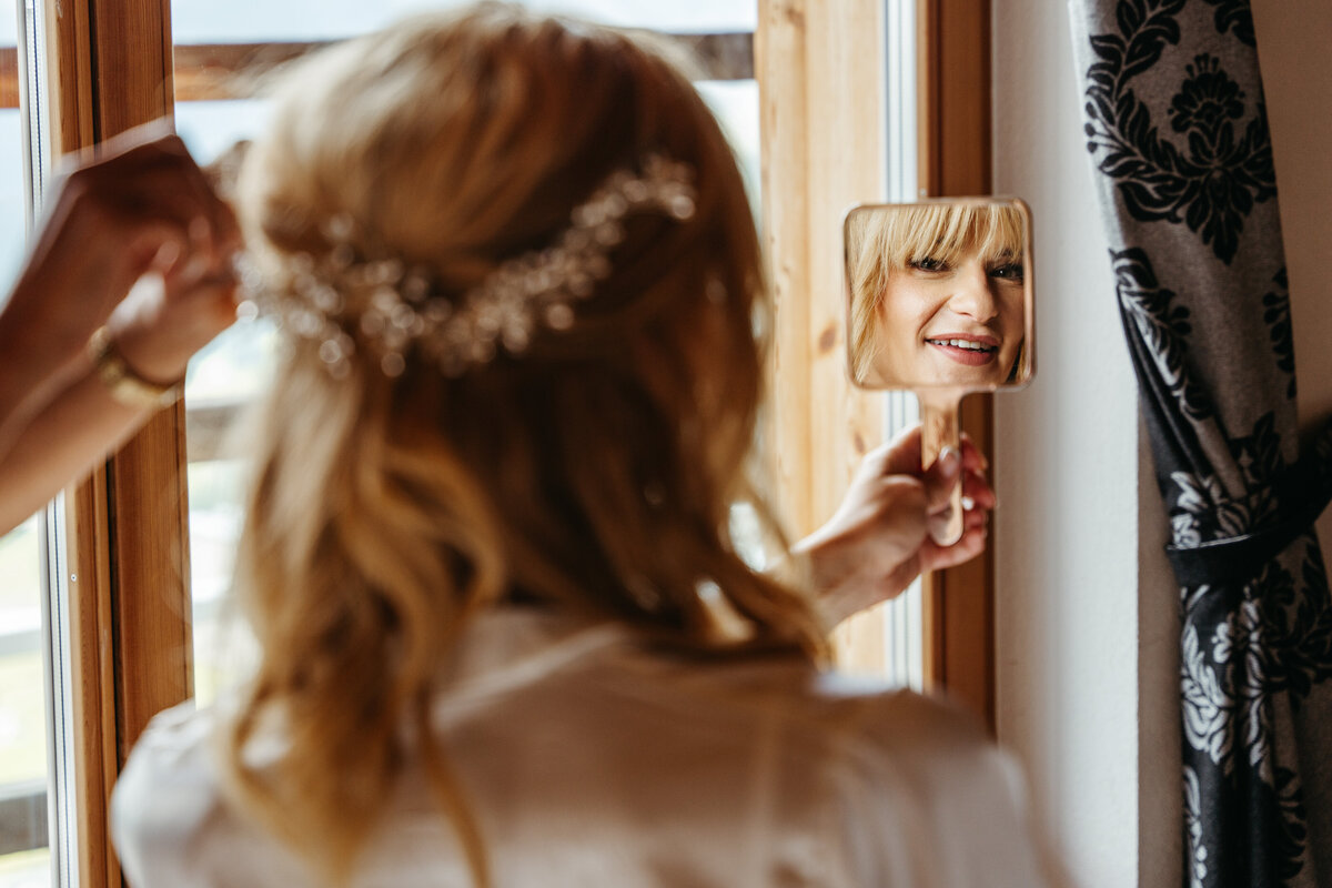 Bride’s reflection in mirror during hair and makeup