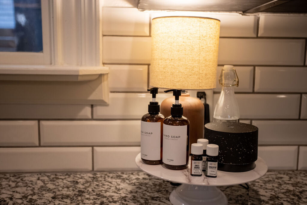 Top quality soaps and essential oil diffuser in the kitchen of this three-bedroom, two-bathroom mid-century house that sleeps 8 and boasts a unique experience in color, style, and lifestyle products located in the heart of Waco, TX.