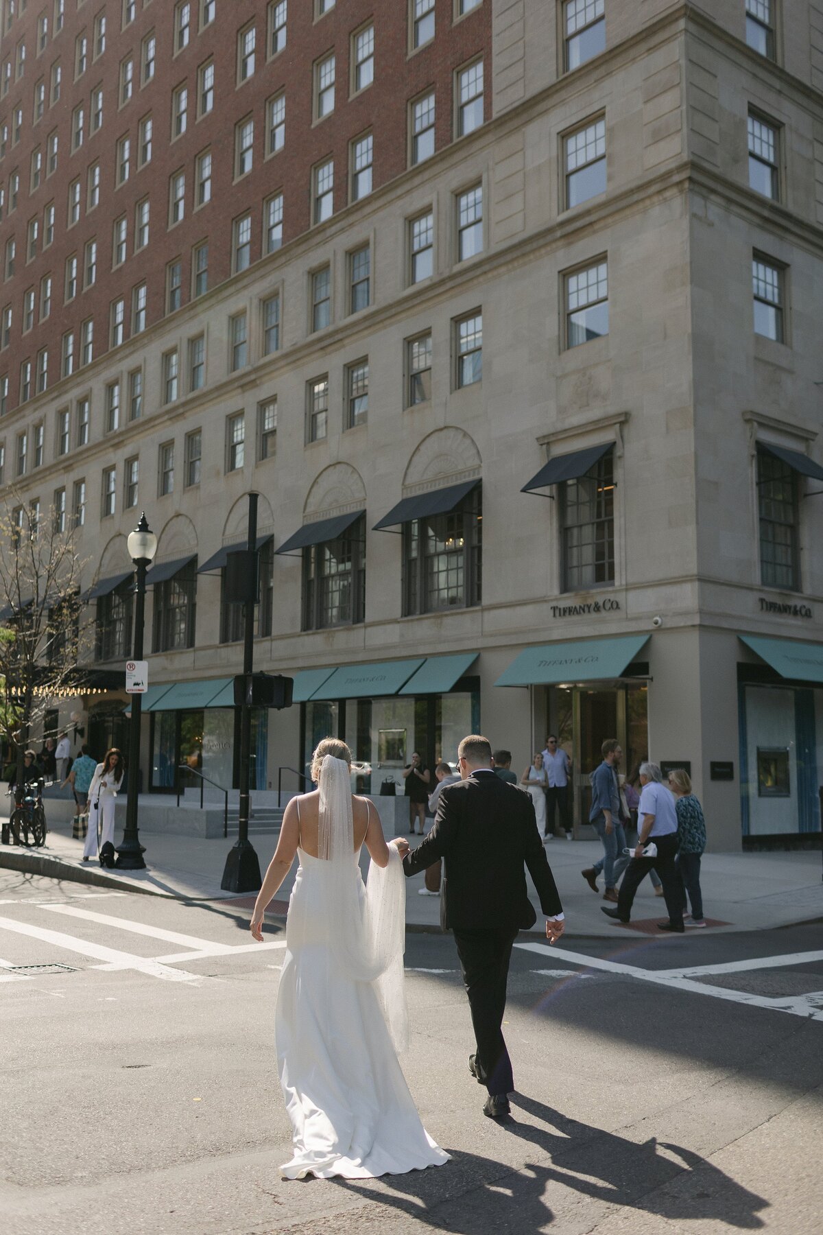 Bride and Groom walk across the street towards The Newbury Boston.