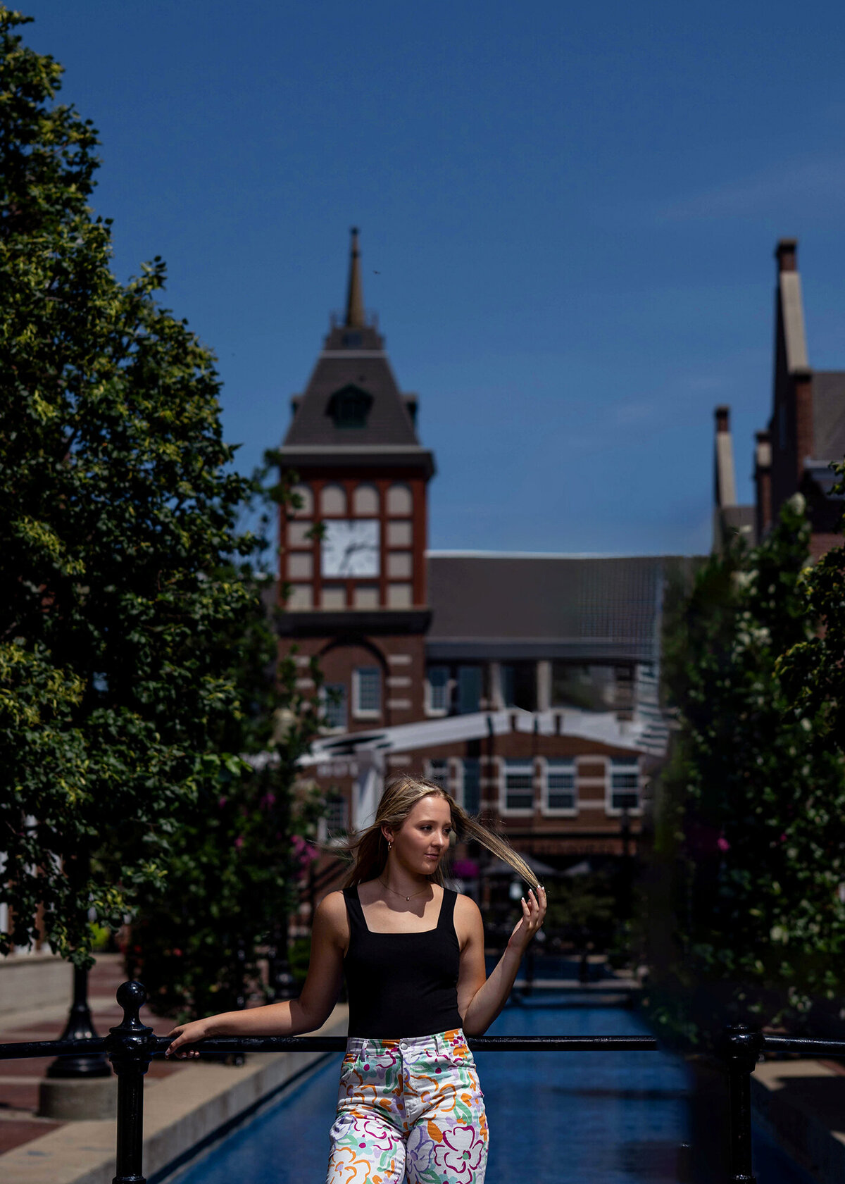 A high school grad leans on a railing surrounded by Iowa history