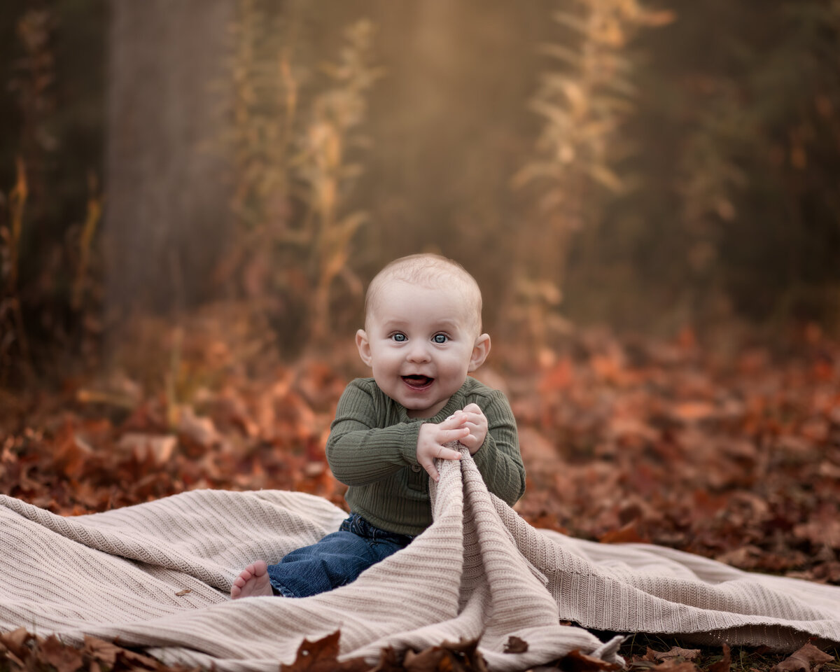 A cozy autumn milestone photo of a smiling baby in Ayr, Ontario—capturing nature’s warmth and childhood wonder in the fall.