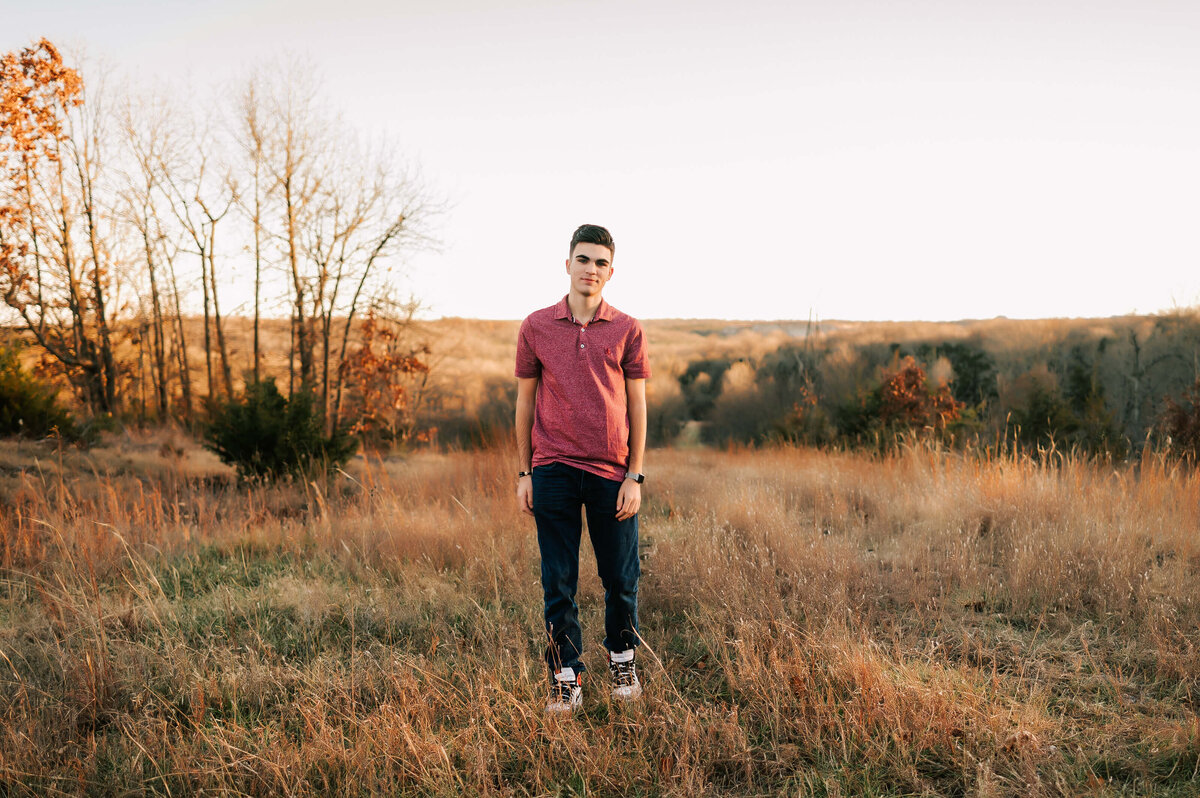 senior picture in Branson MO of high school senior boy walking in a field