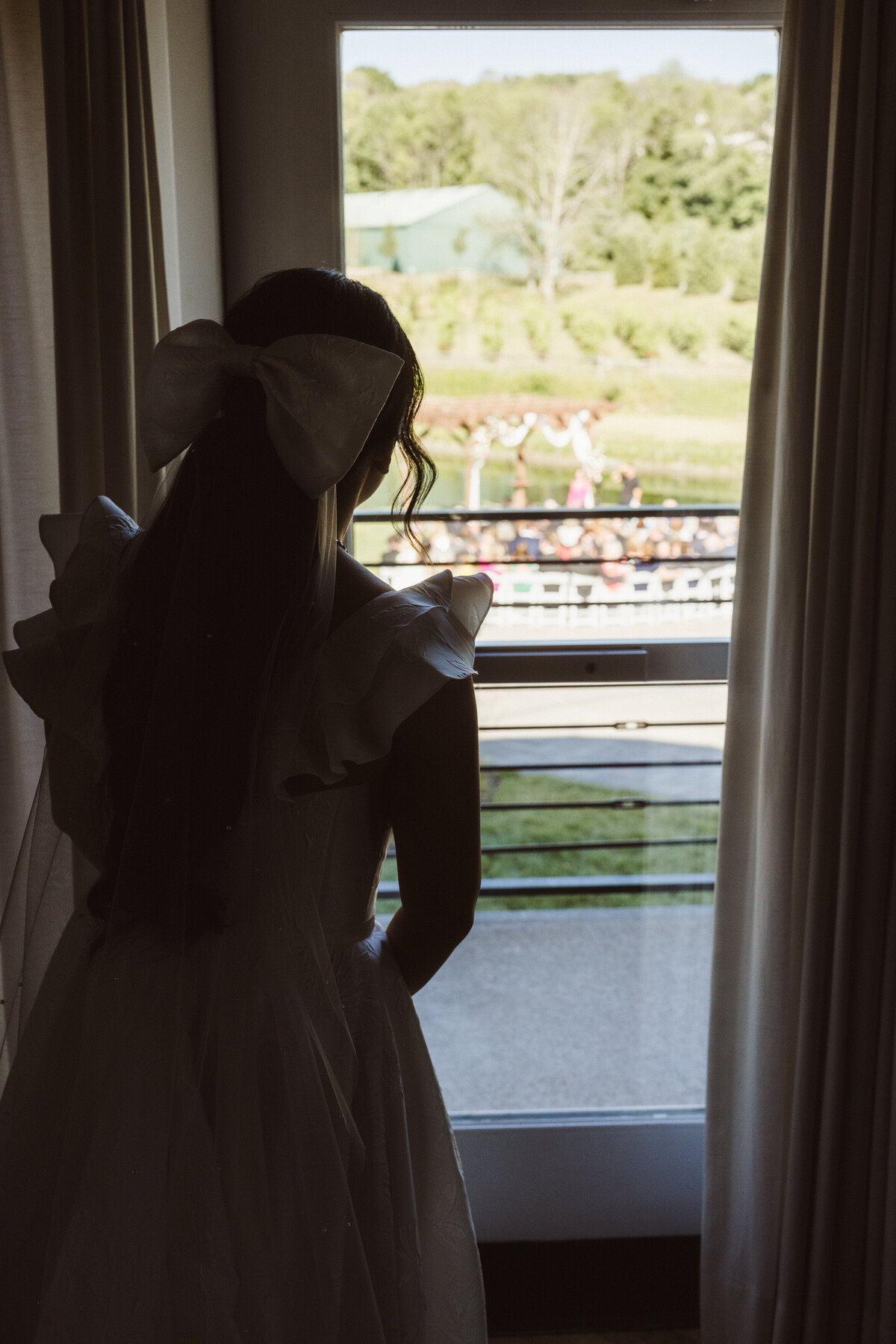 pre ceremony wedding candid of bride looking outside