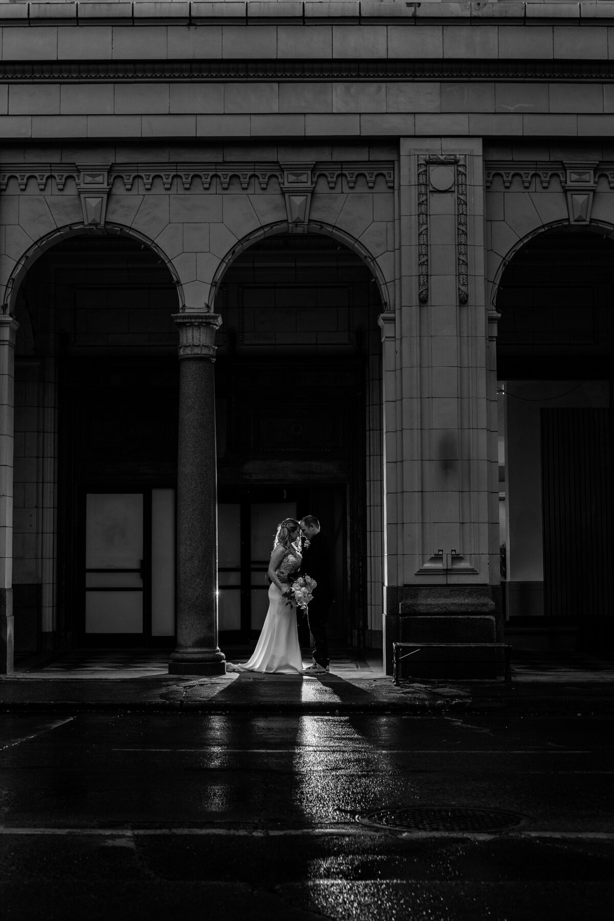 Wedding portrait of a couple kissing at the Calgary Bay arches lit by a flash