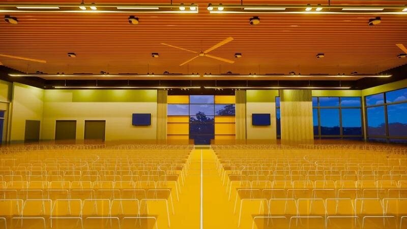Indoor gymnasium or performance hall with polished wooden flooring and brightly colored stage area at St Gabriel School.