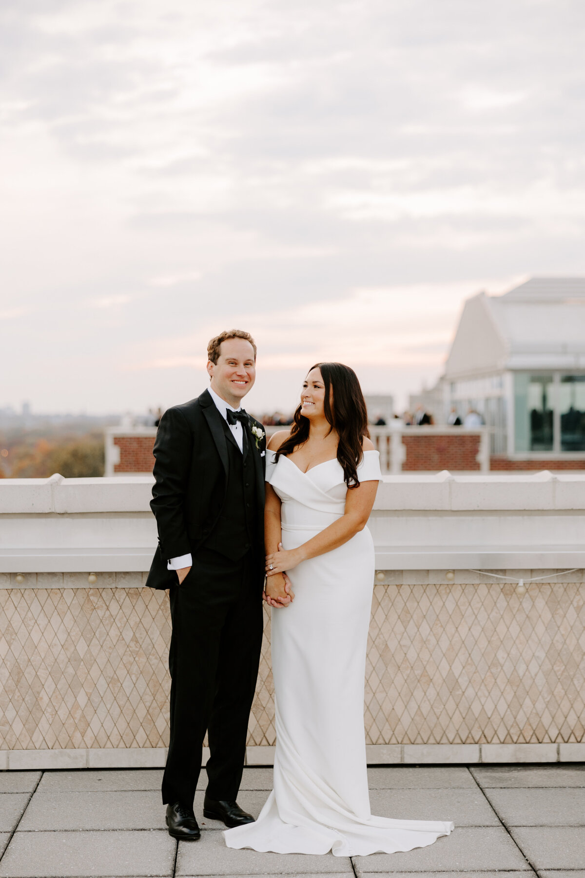 Bride and groom holding hands for photo at Chase Park Plaza wedding on balcony