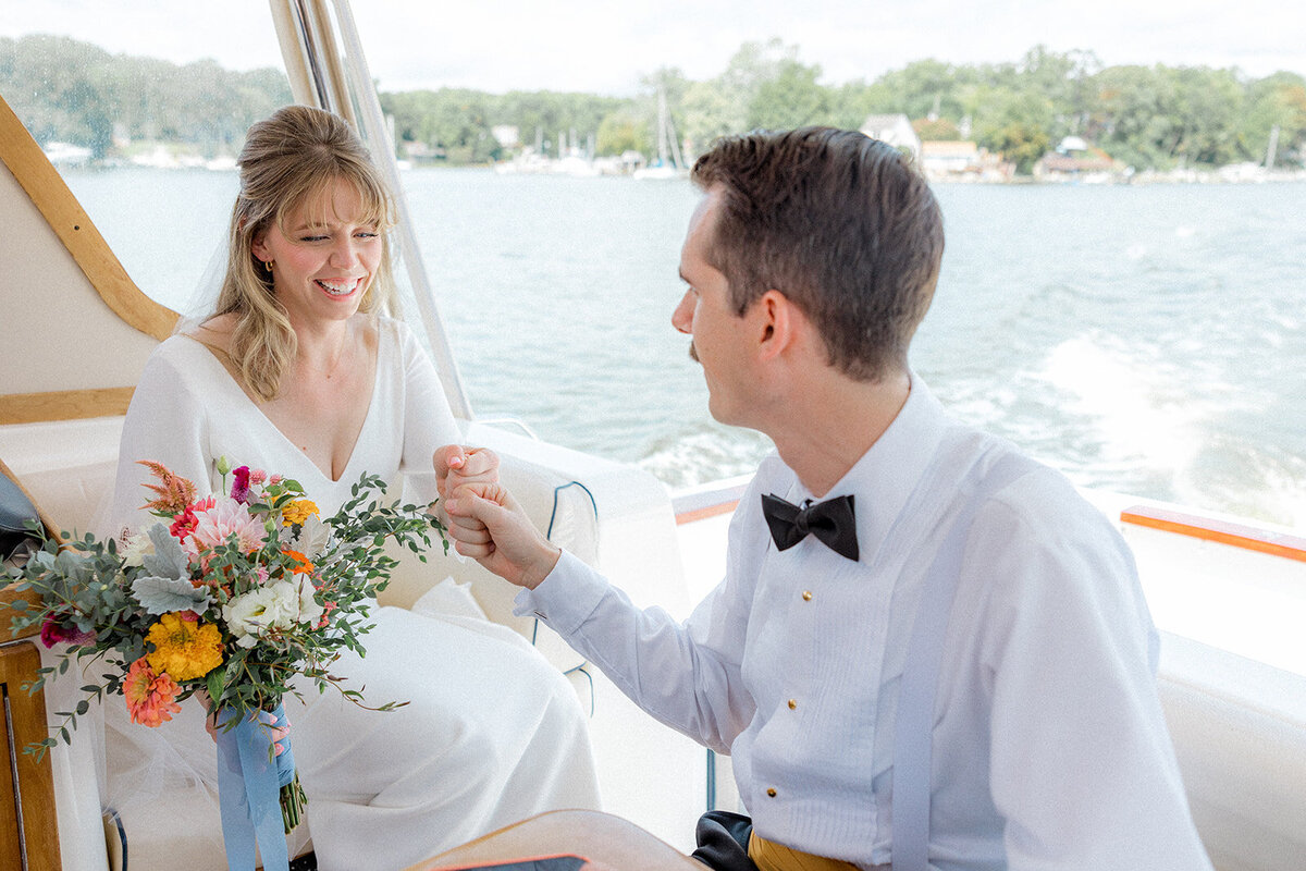 Bride and groom fist bumping on boat