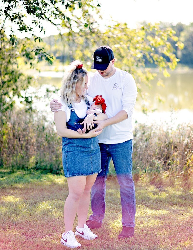 parents with baby by lake