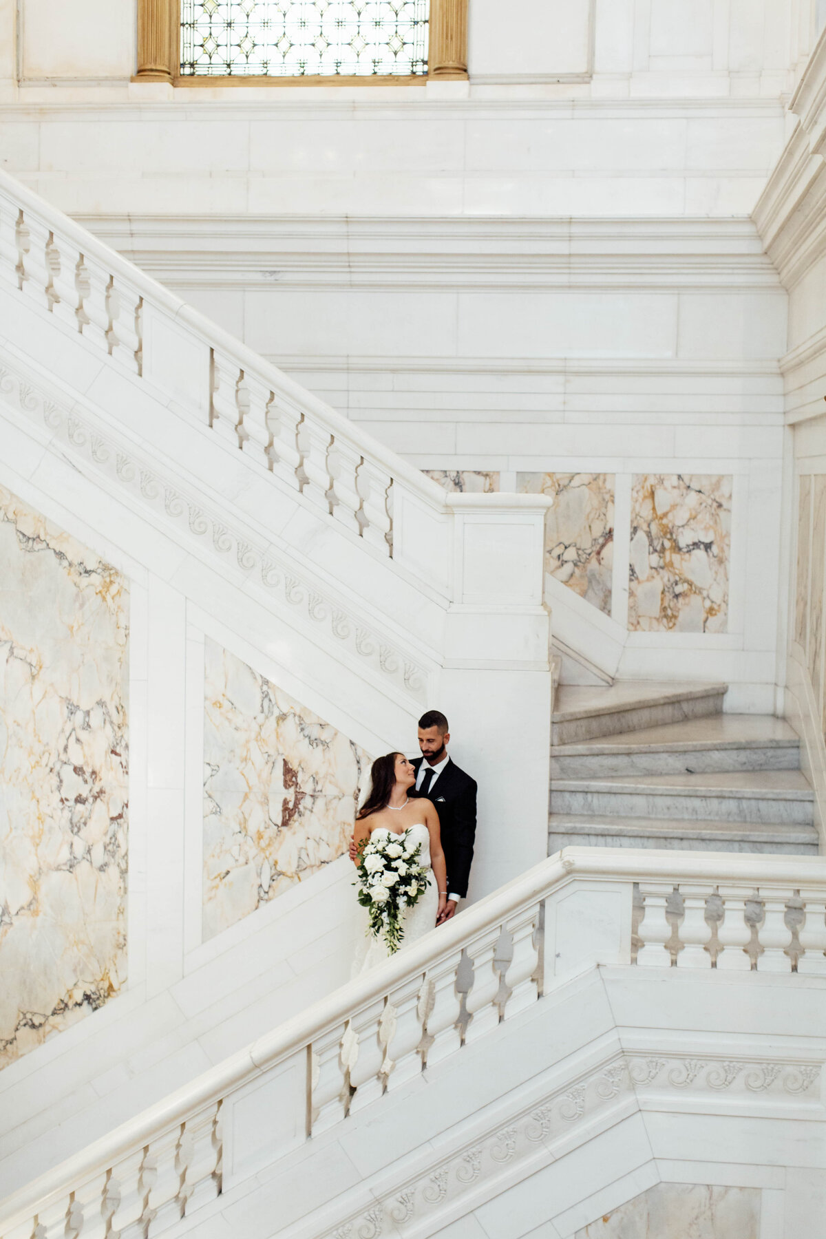 Bride and groom embracing at on stairs.
