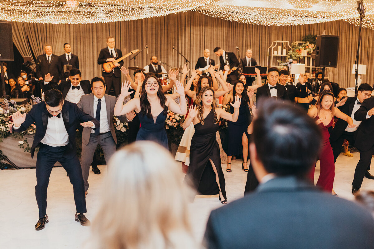 guests put together a flash mob for the bride and groom as a surprise at their wedding reception.