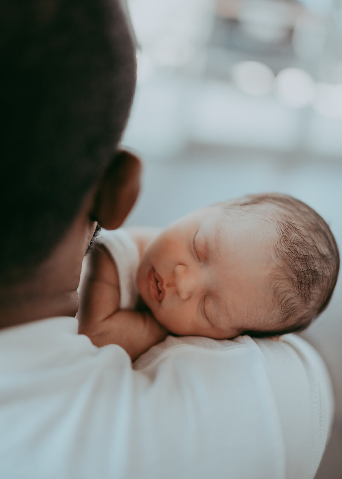 newborn baby sleeps on her dad's shoulder during photo session near denver colorado