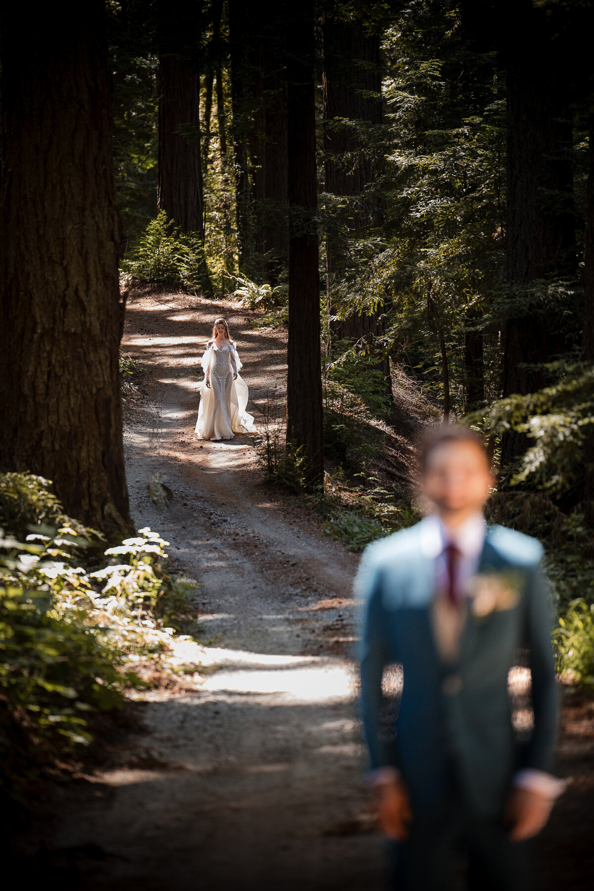 A bride walks down a long path towards her first look at a destination wedding at Nestldown in Los Gatos, California