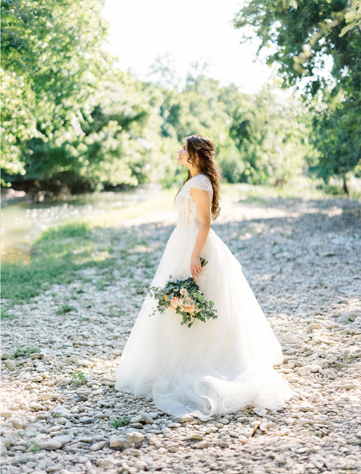 Bride stands by the river