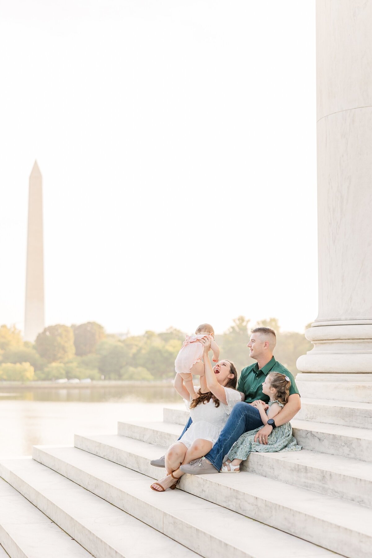 Family sitting on the steps of the Jefferson Memorial at sunrise