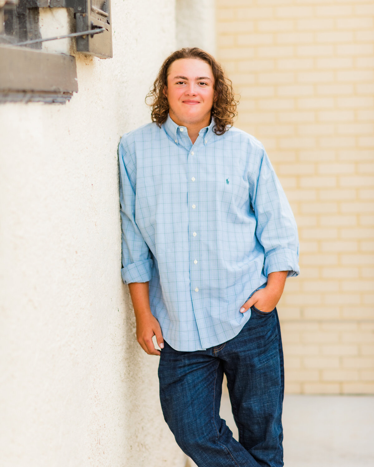 long hair senior guy leans on wall-8667