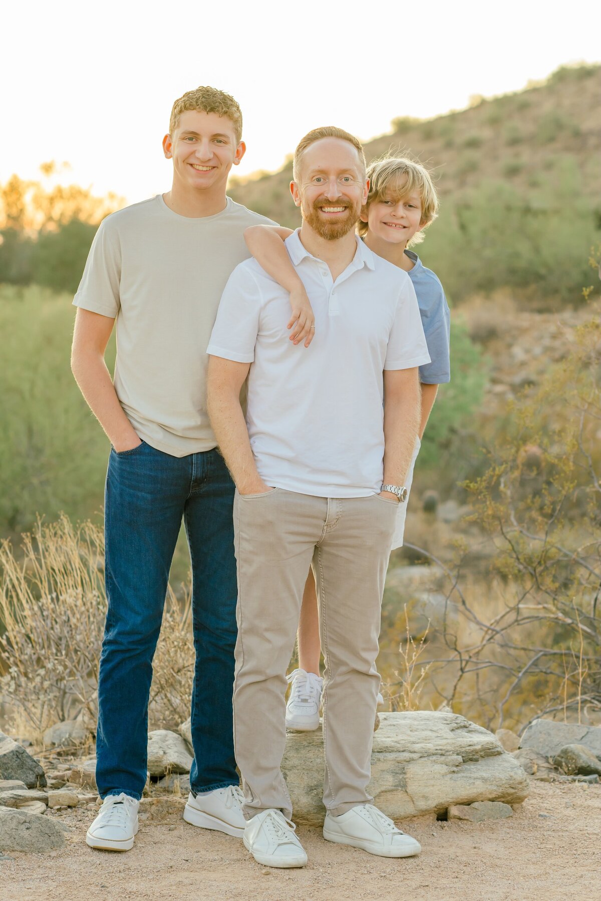 father and two sons in arizona desert smiling at the camera 