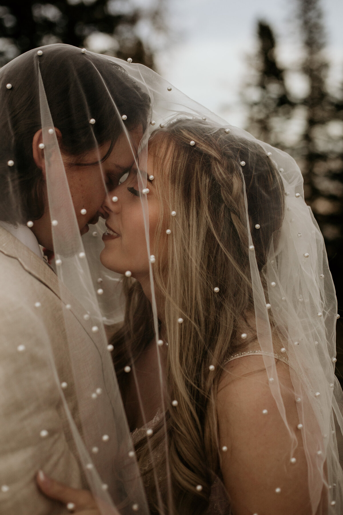 bride and groom about to kiss under her veil