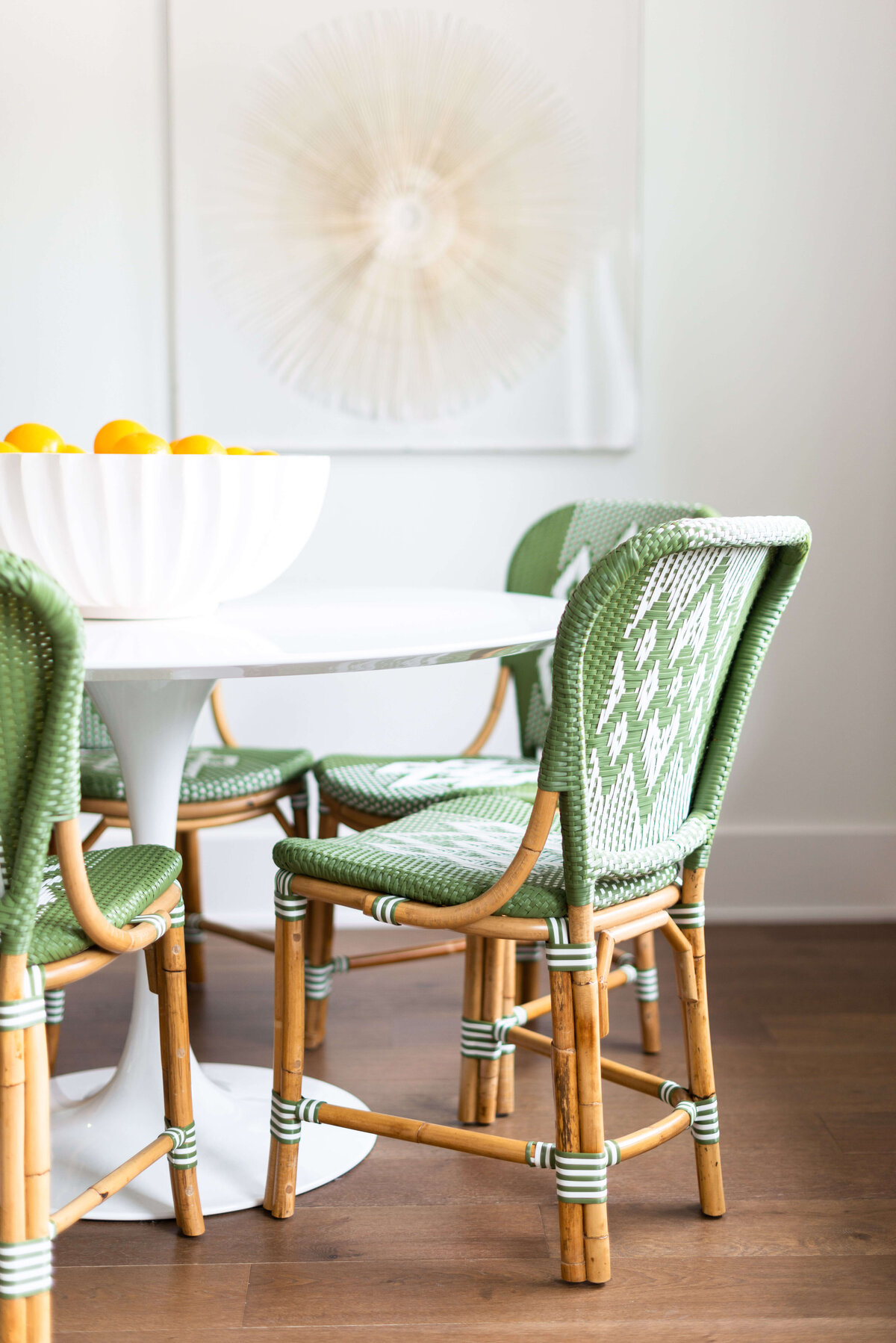 oyster creek studios building belt new build wooden chairs with green wicker accents around white table in dining area