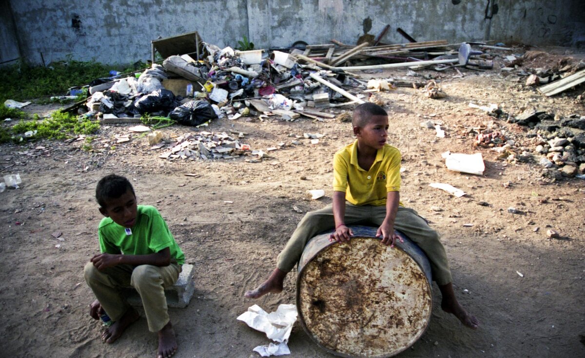 Children play with trash and old oil drum at orphanage in Santo Domingo