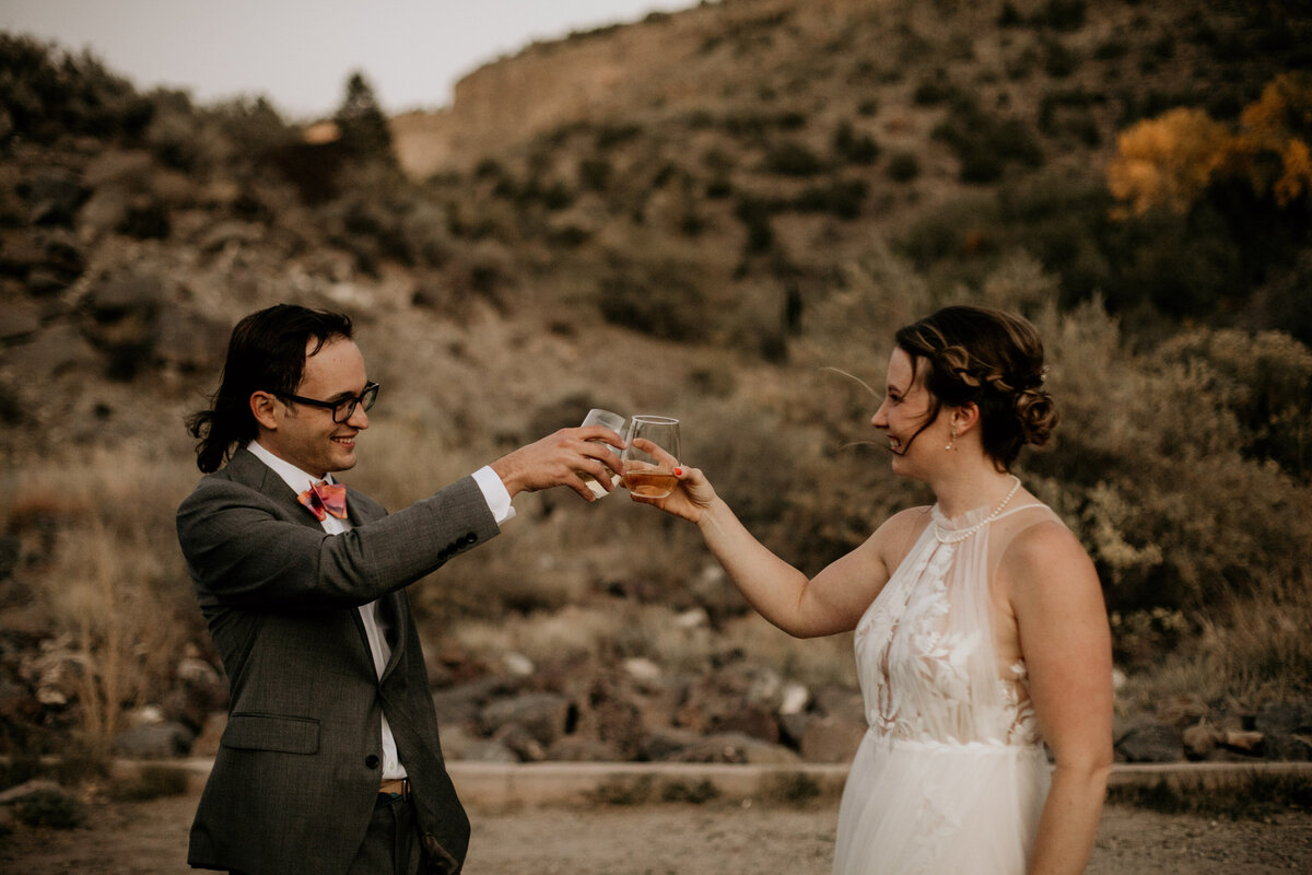 bride and groom toasting in the desert