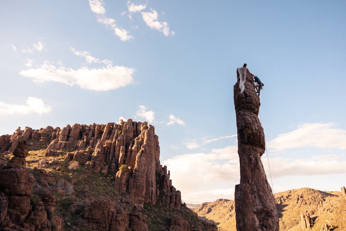 Bride and groom climbing Totem Pole after their wedding ceremony.