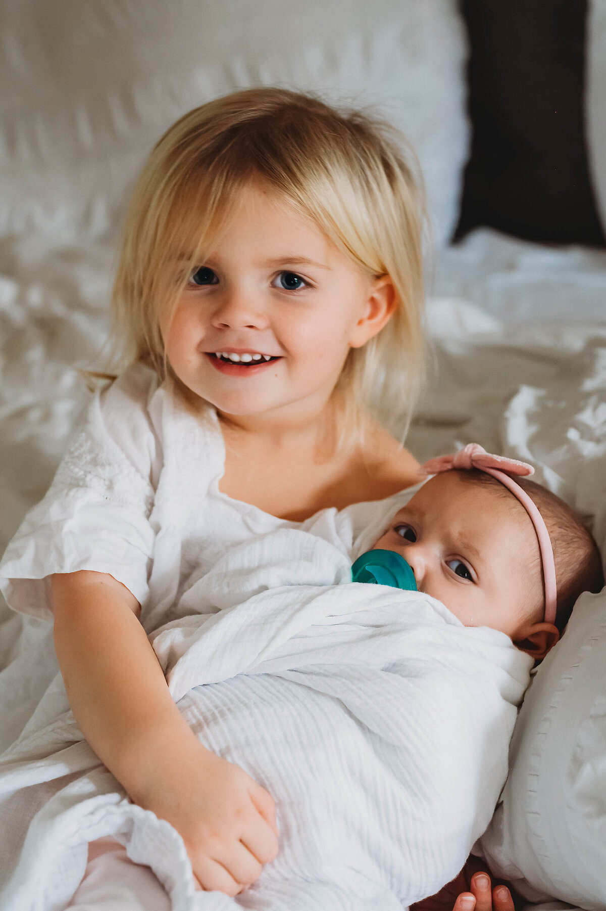 newborn-with-toddler-sister-holding-her