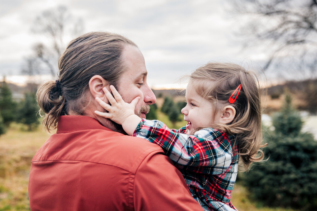 Daughter hugging father at a Christmas tree farm in Somerset County, NJ