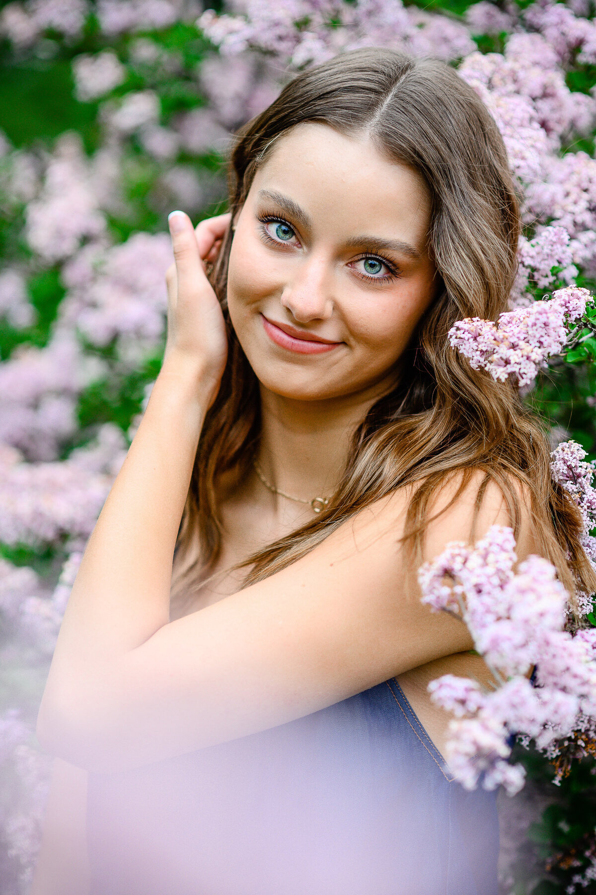 Denver Botanic Garden senior pictures of a girl surrounded by purple flowers with her bright blue eyes piercing for her denver senior photos