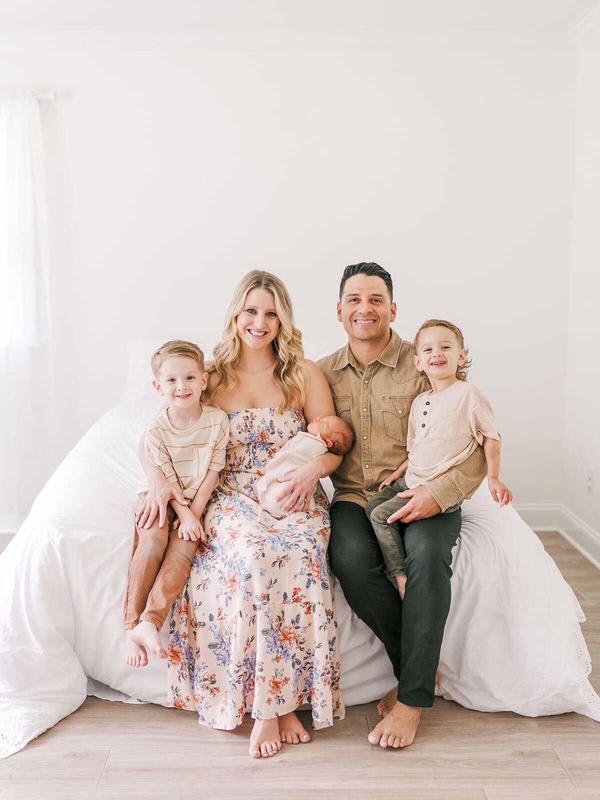 Mom and dad holding their three boys.