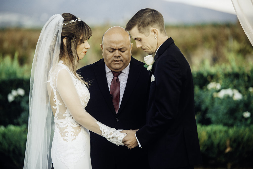Wedding Photograph Of Bride And Groom Holding Hands in Front Of Pastor Los Angeles