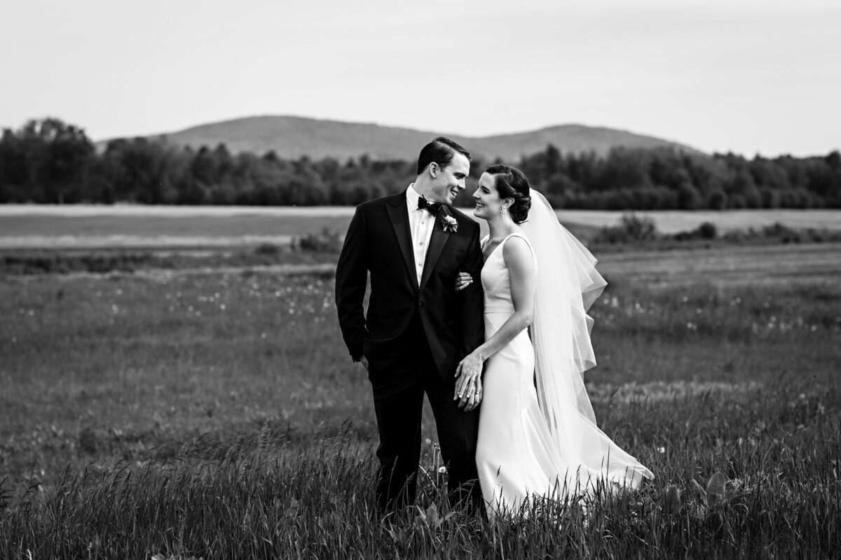 The newlyweds enjoy a little time together in front of the mountains after their Hardy Farm Maine wedding