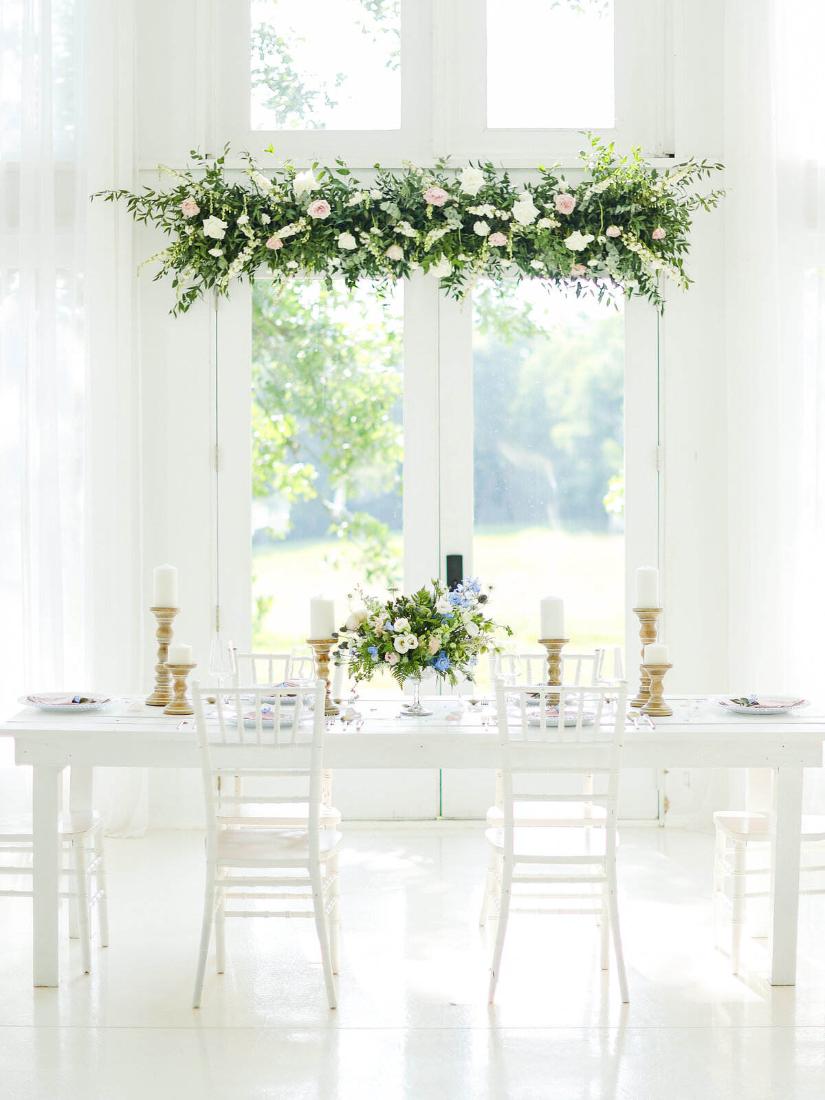 Elegant wedding reception decor with floral arrangements and white chairs, captured by fine art wedding photographer Abby Bell in Alabama.