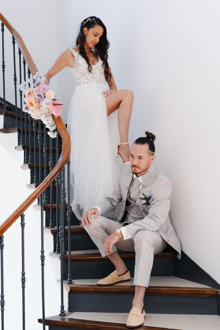 Wedding-couple-on-the-staircase-holding-a-pastel-bouquet