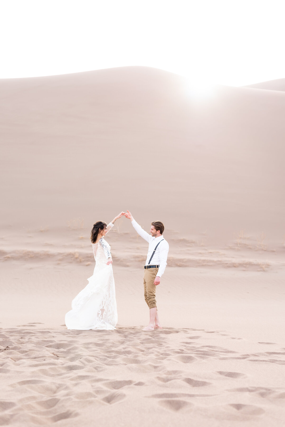 Bride twirling around in her dress at Great Sand Dunes National Park in Colorado